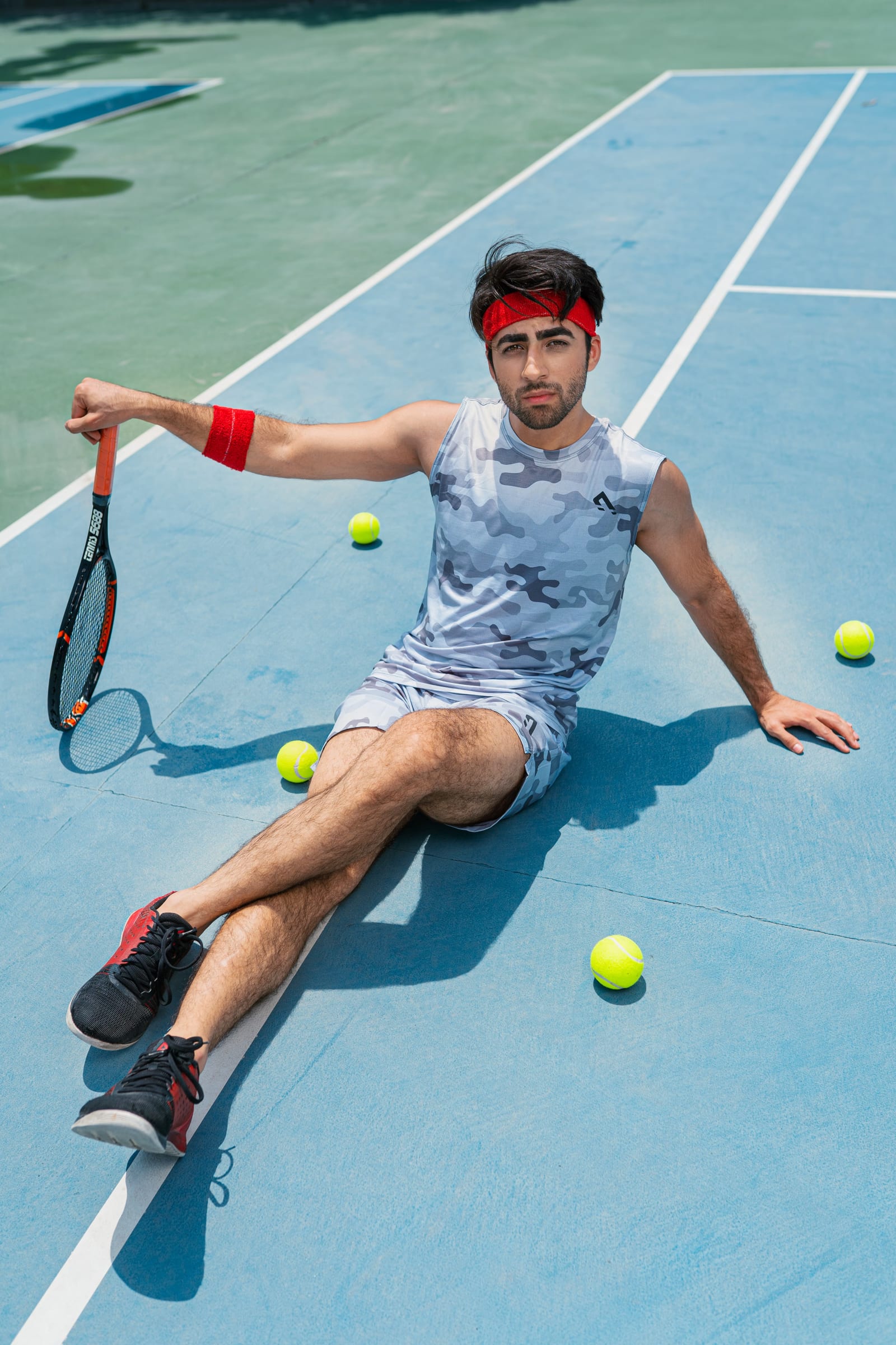 Player sitting on a blue court with a racket
