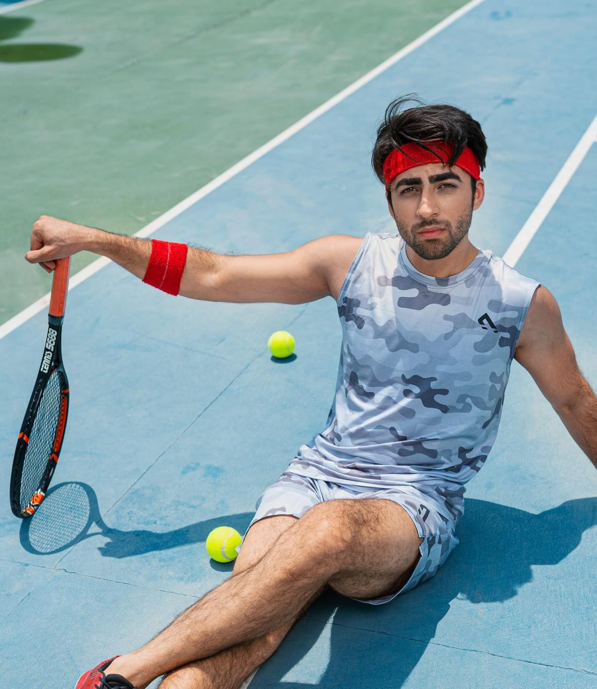 Player sitting on a blue court with a racket