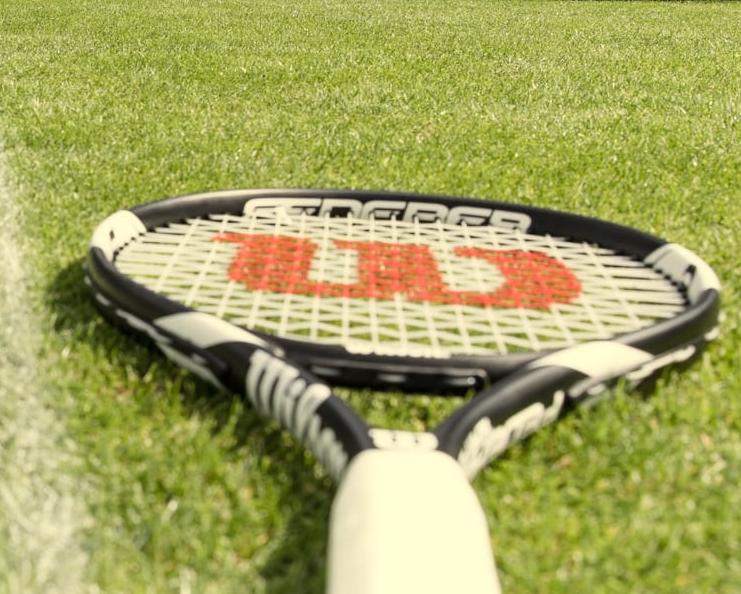 Racket and ball on a grass court