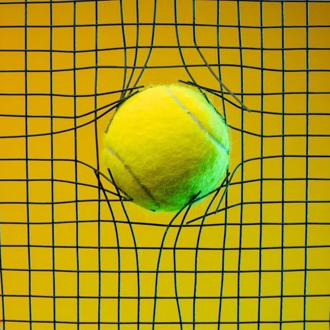 Tennis ball pressed into racket strings