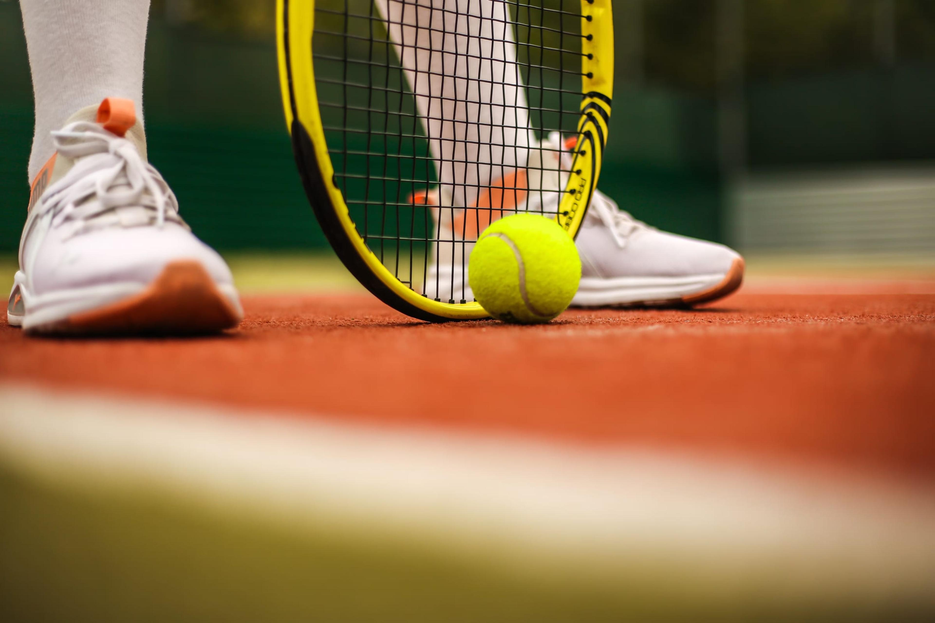 Player's shoes and racket on a clay court