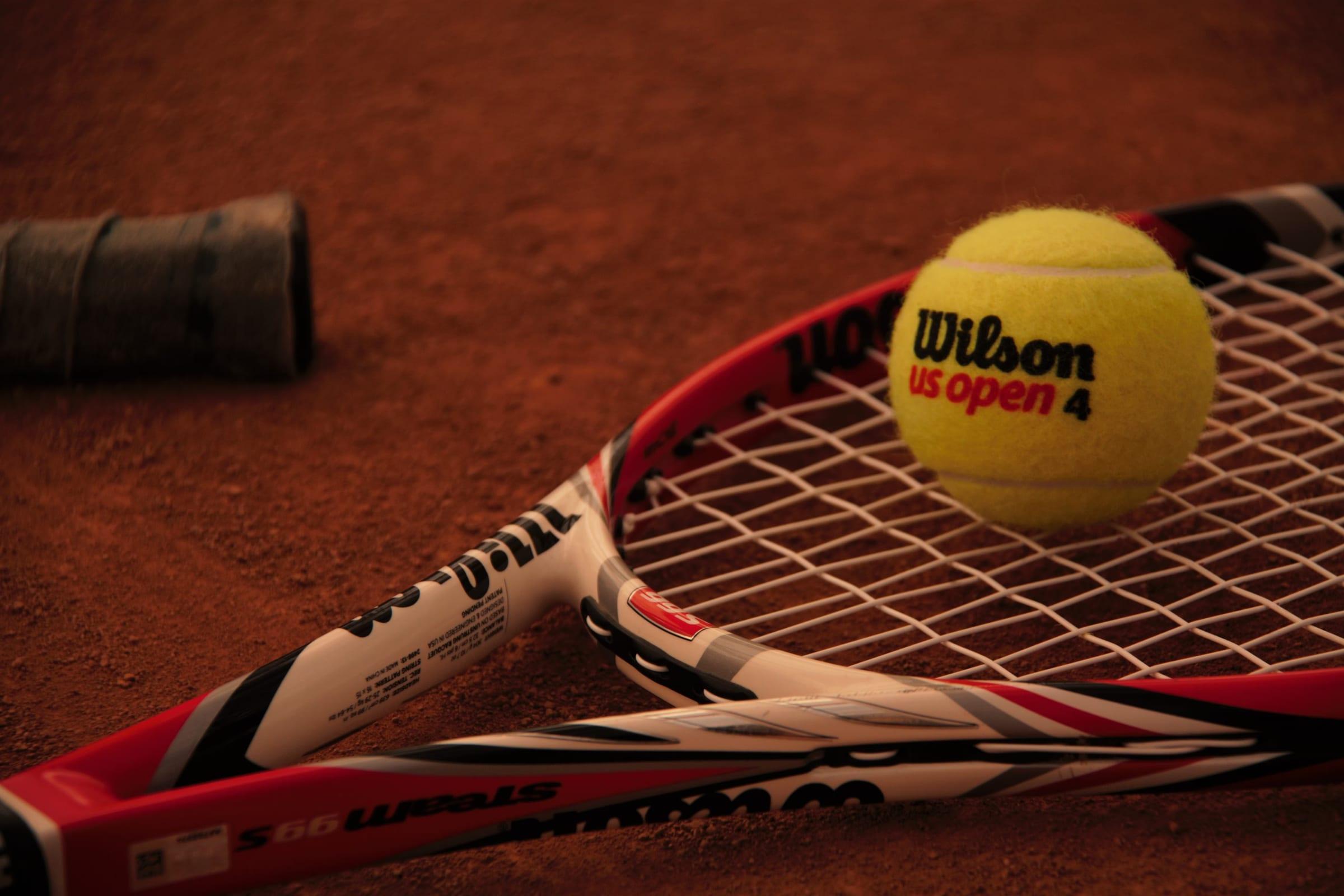 Ball resting on a racket on clay