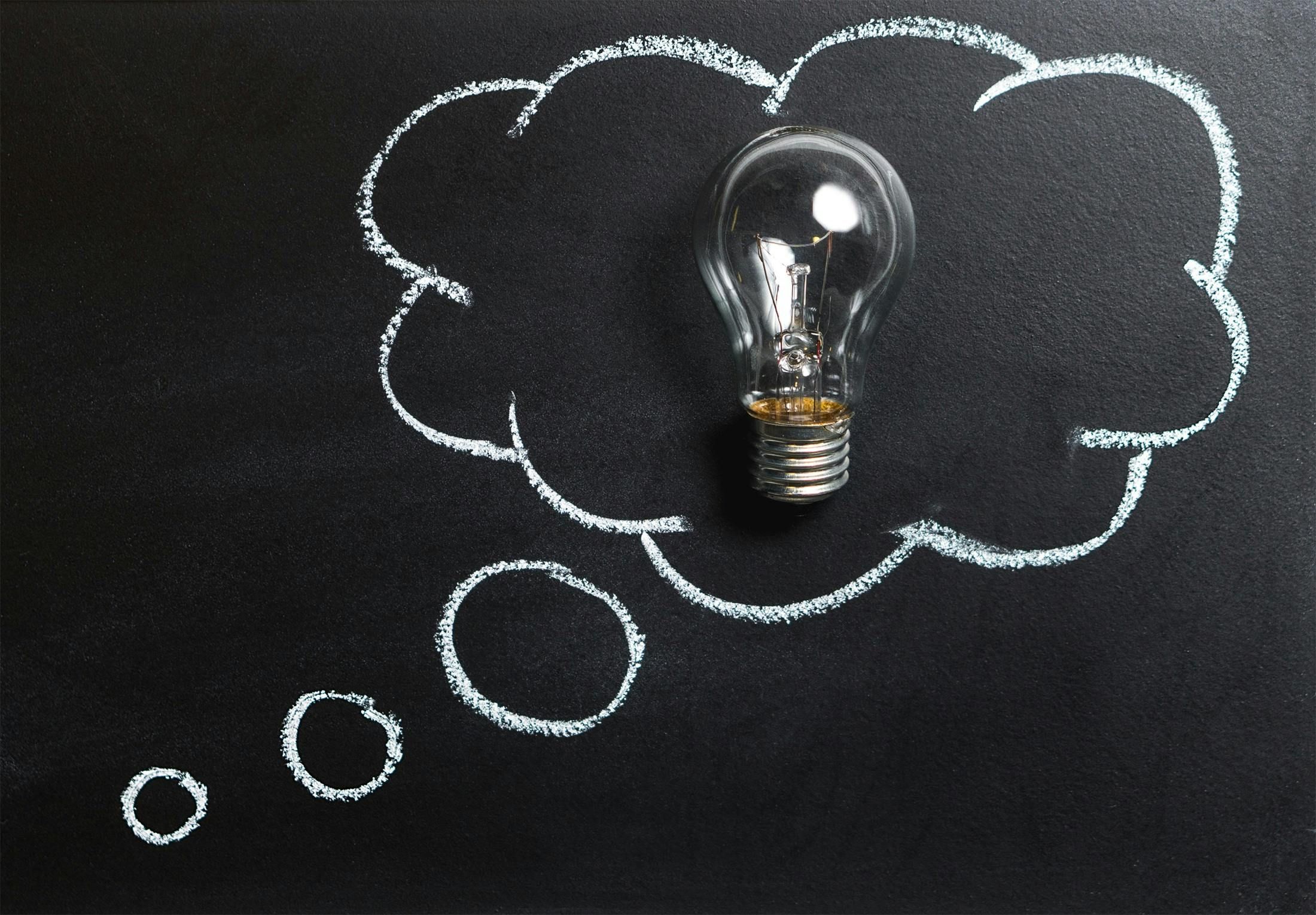 A light bulb drawn inside a chalk thought bubble