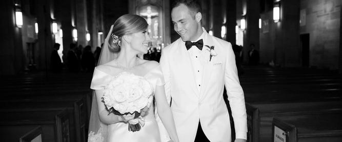 A bride and groom walk hand-in-hand down the aisle.