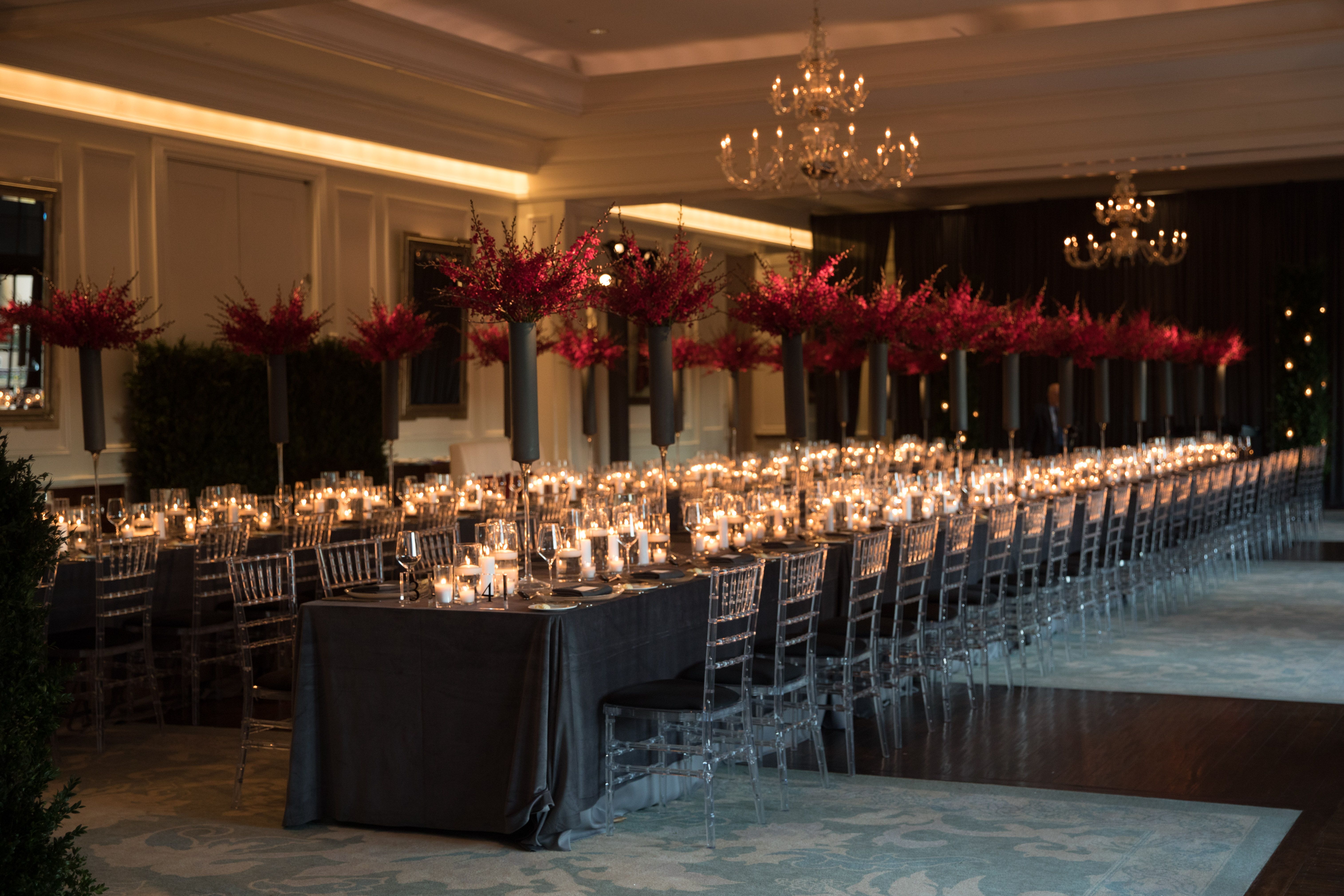 Long banquet tables with dramatic floral decor.