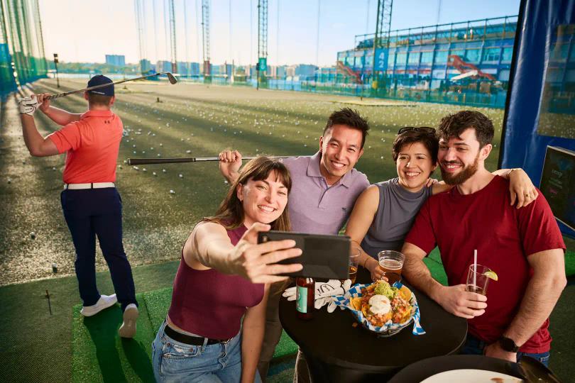 Golfers having fun at the driving range at Chelsea Piers