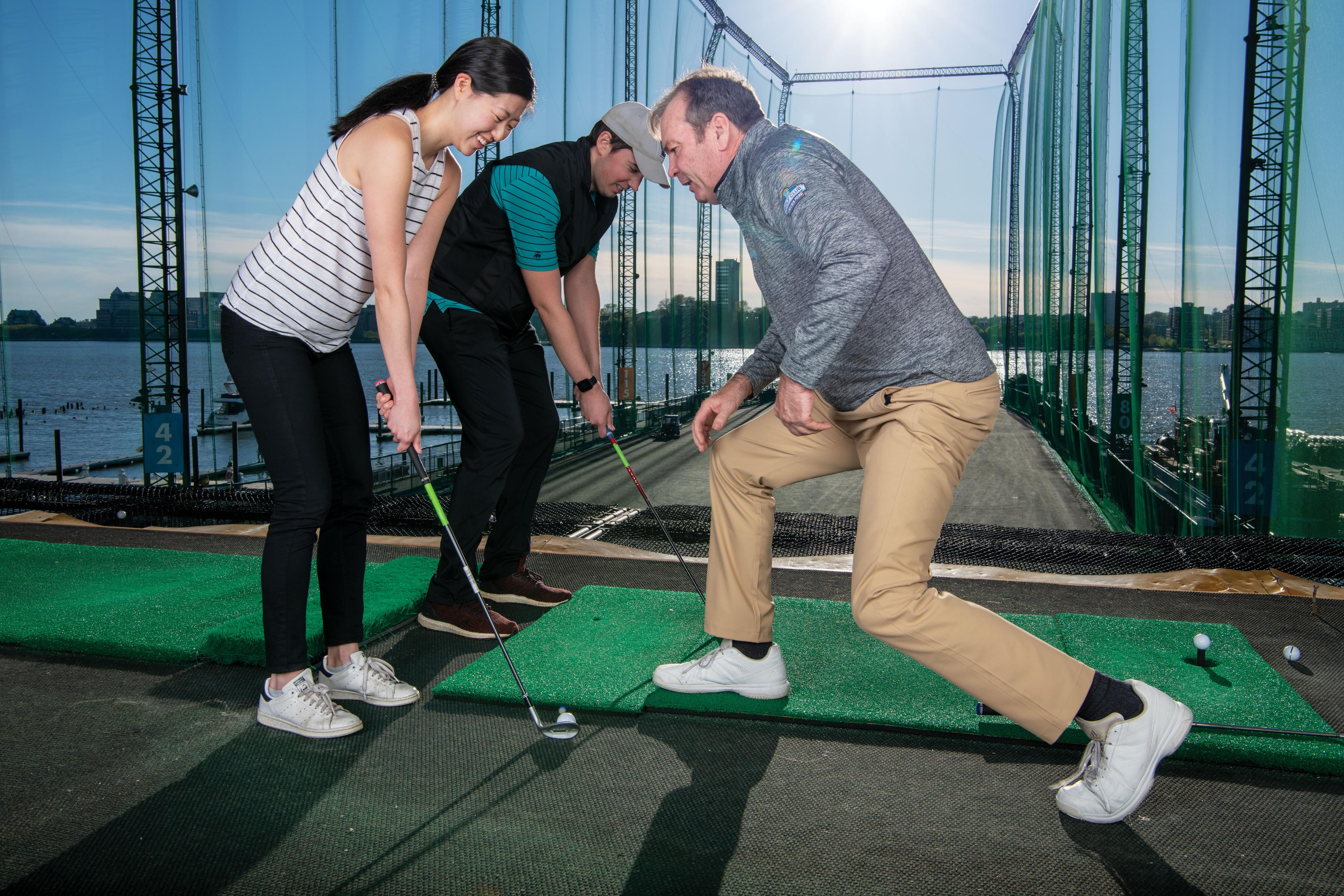 Male and female with a golf pro