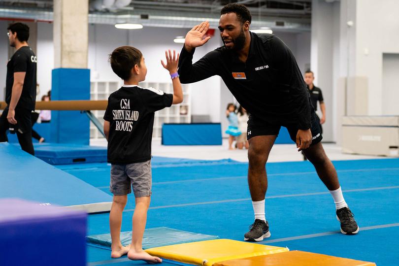 Kid high-fiving a coach in a gymnasium
