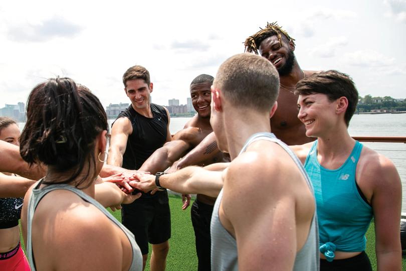Group in a circle with their hands in