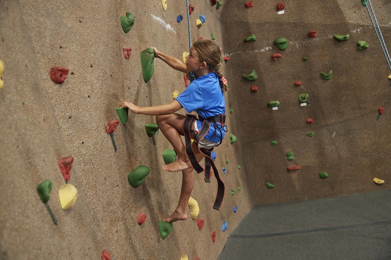 girl climbing a rock wall