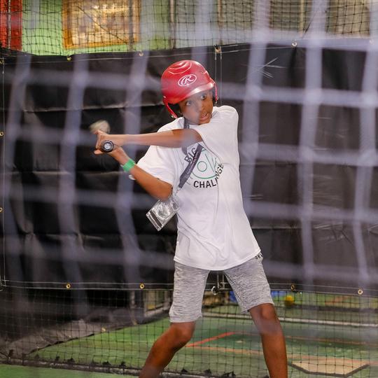 Boy swinging in the batting cages