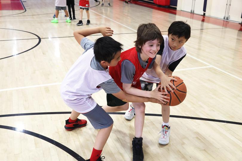 Boy dribbling a ball on a basketball court