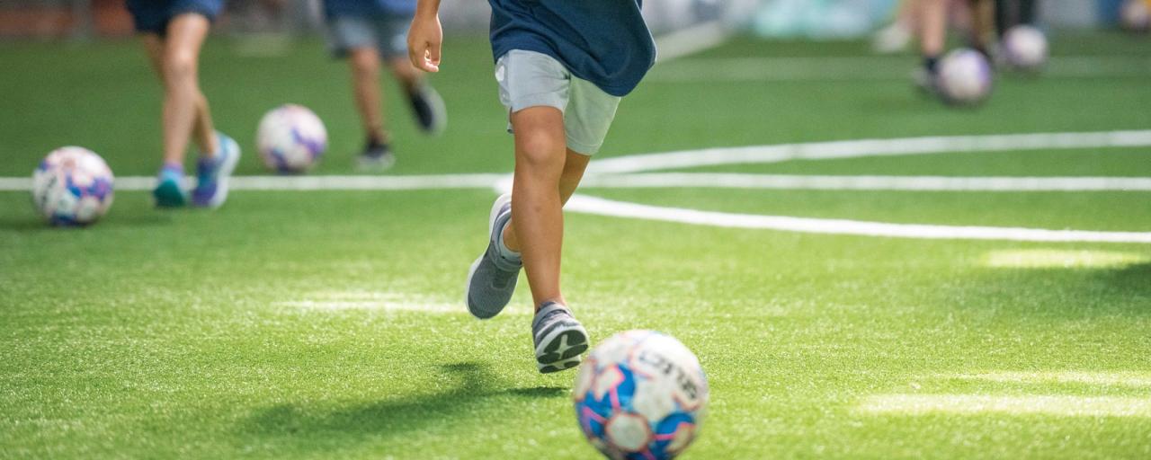Kicking a soccer ball on the field