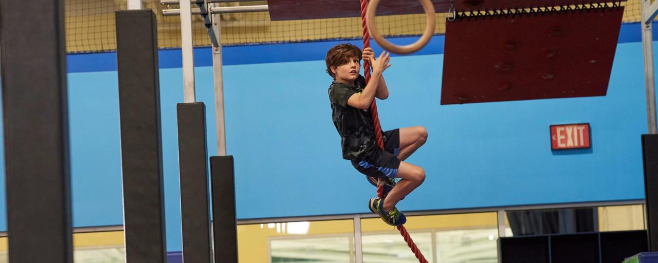 Kid completing an obstacle on a rope