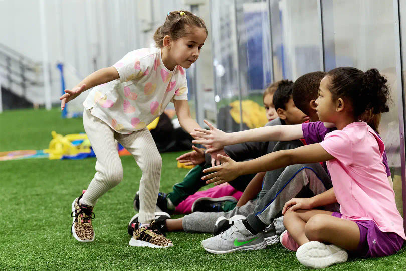 Girl high fiving teammates on soccer turf