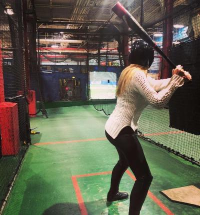 Girl batting in a batting cage