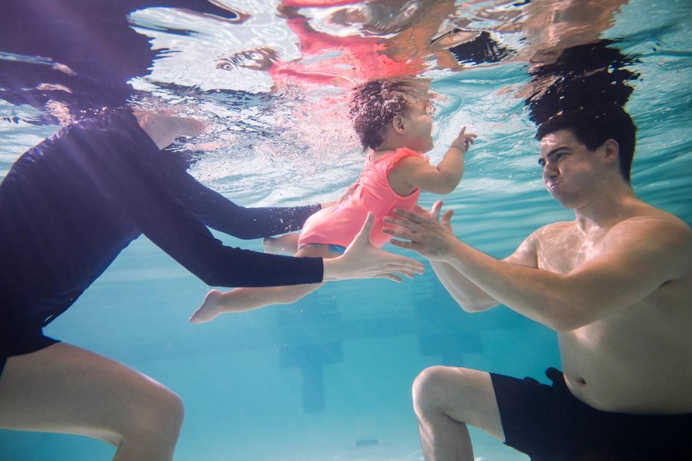 Young swimmer with coach and caregiver