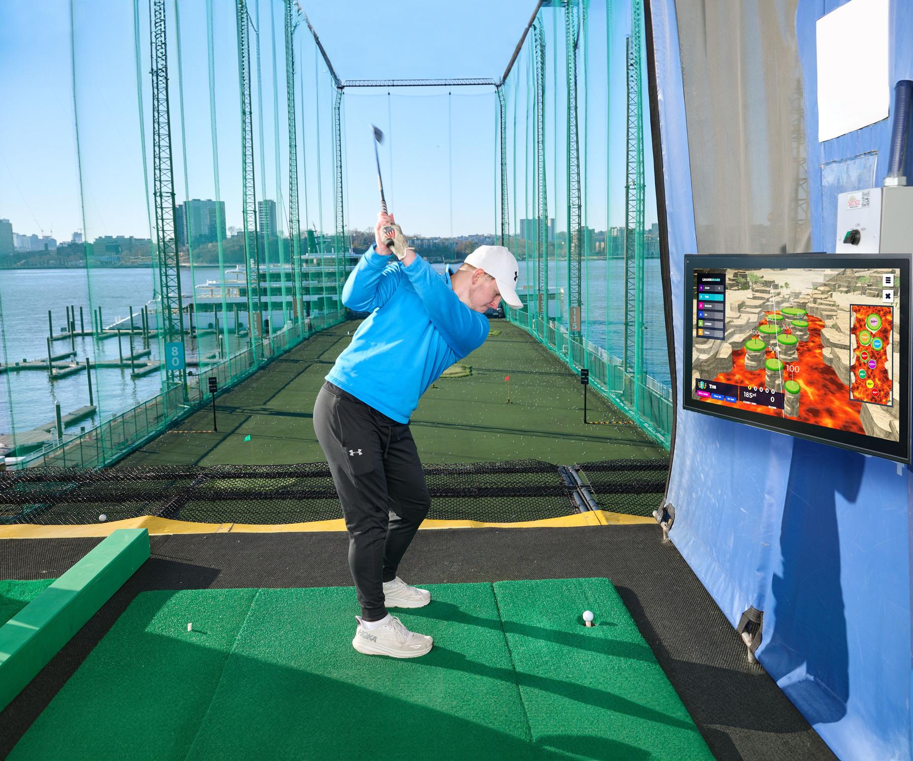 Hitting golf balls at Chelsea Piers Golf Club driving range