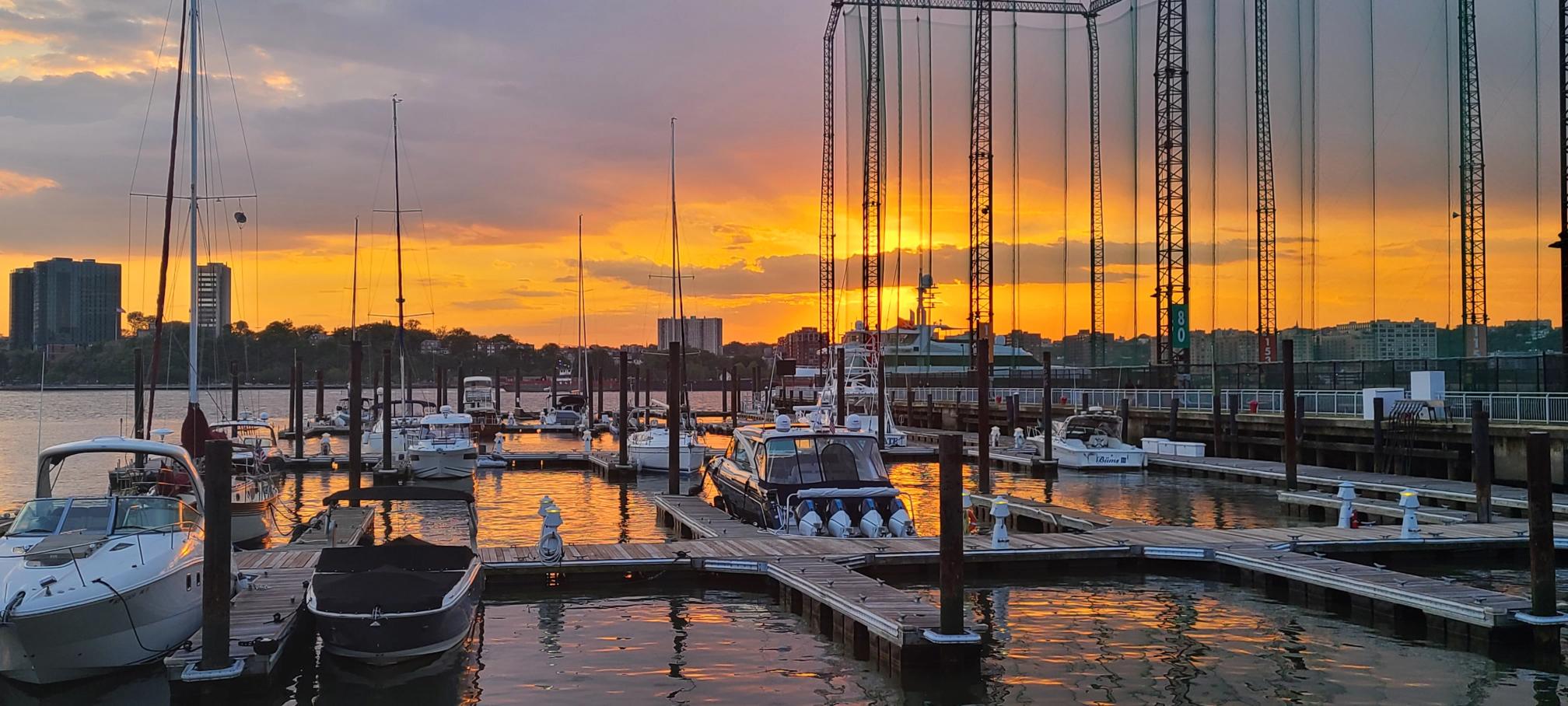 Boats docked at Chelsea Piers Marina at sunset