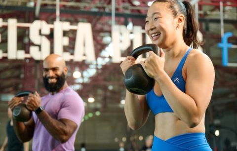 Girl lifting weights with trainer