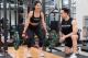 Girl lifting weights with a spotter