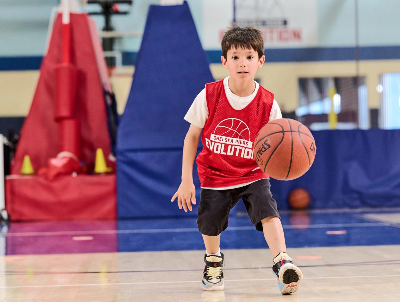 Boy dribbling a ball on a basketball court