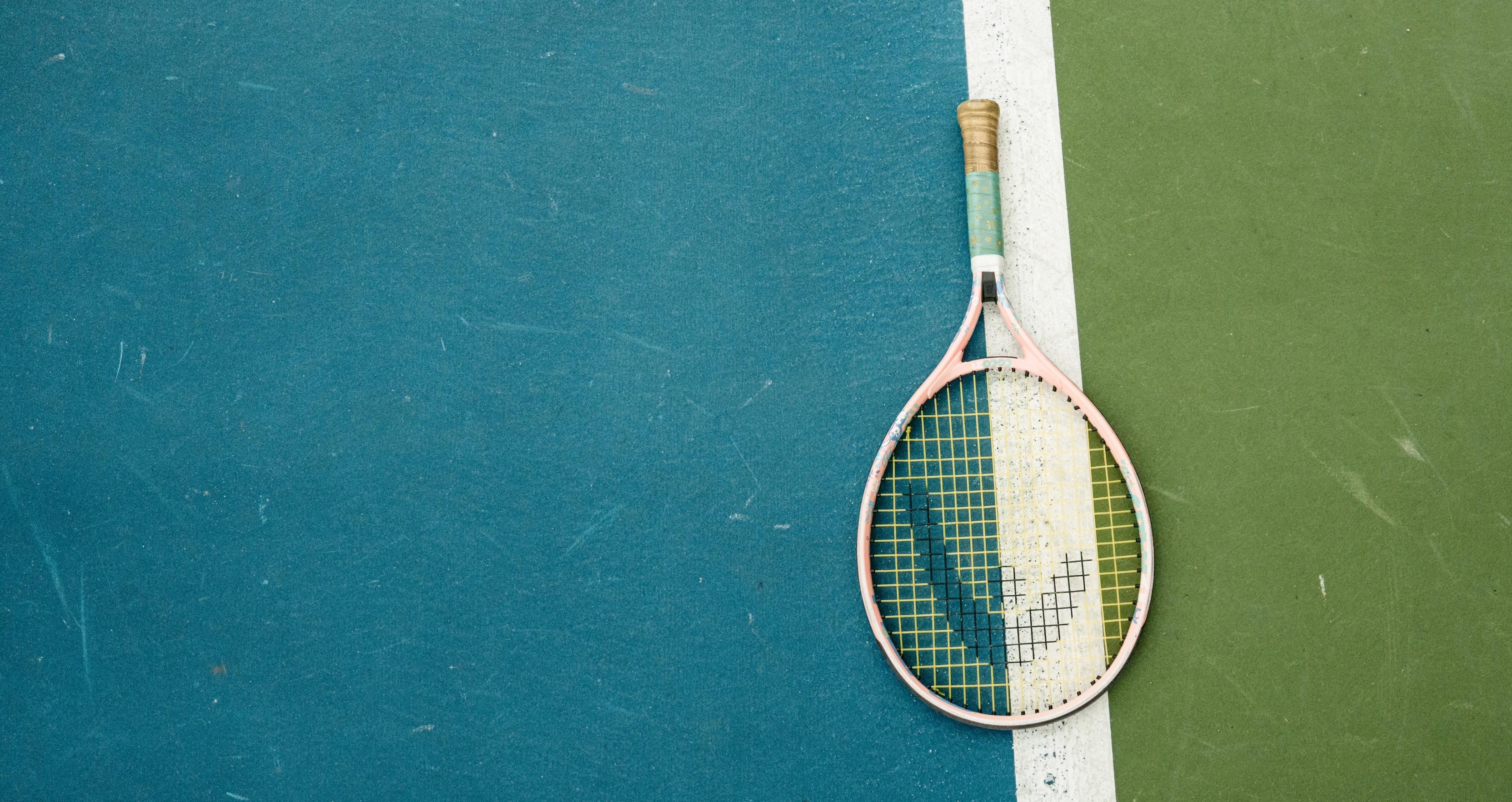 Man and a woman laughing on tennis court