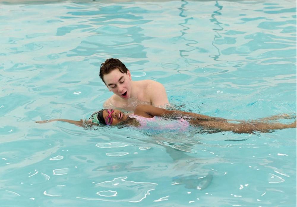 Student swimming with their coach