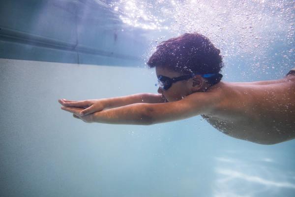 Boy smiling and swimming in the pool