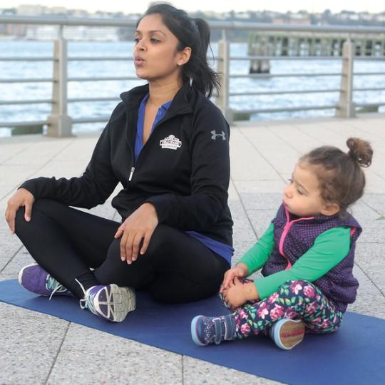 Kid and instructor doing yoga