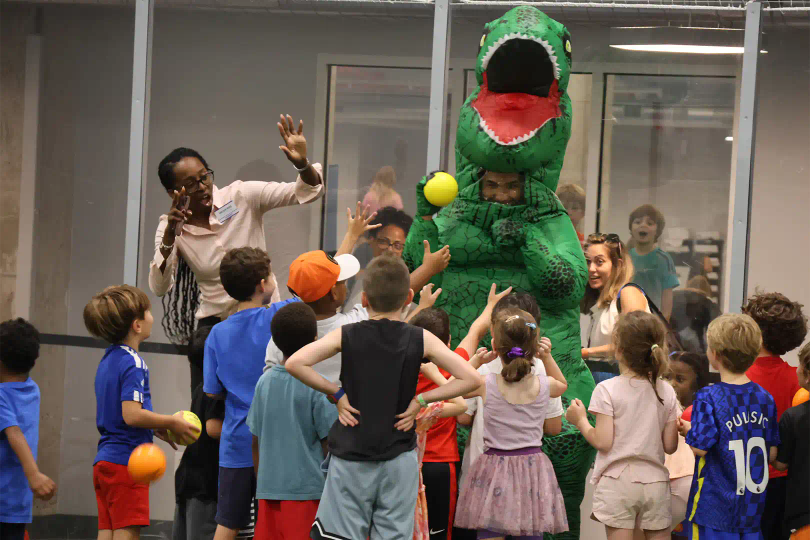 Kids gathering around a dinosaur