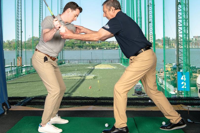 Golf pro helping with form
