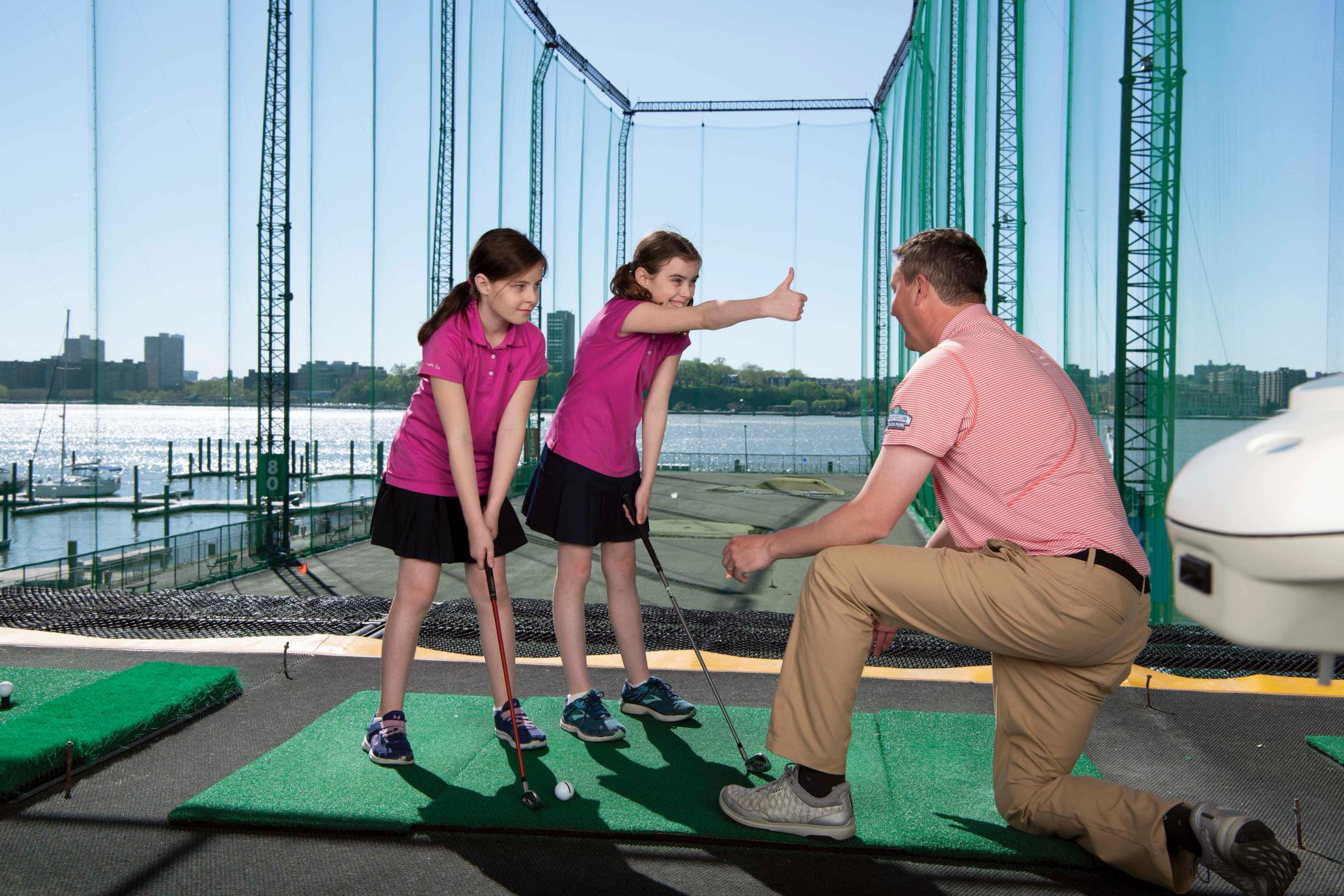 2 golf girls smiling on the range