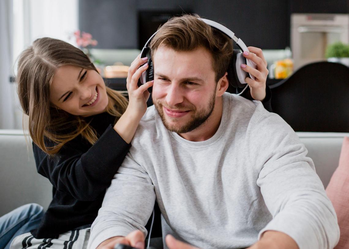 lány fejhallgatót tesz a férfira