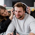 lány fejhallgatót tesz a férfira