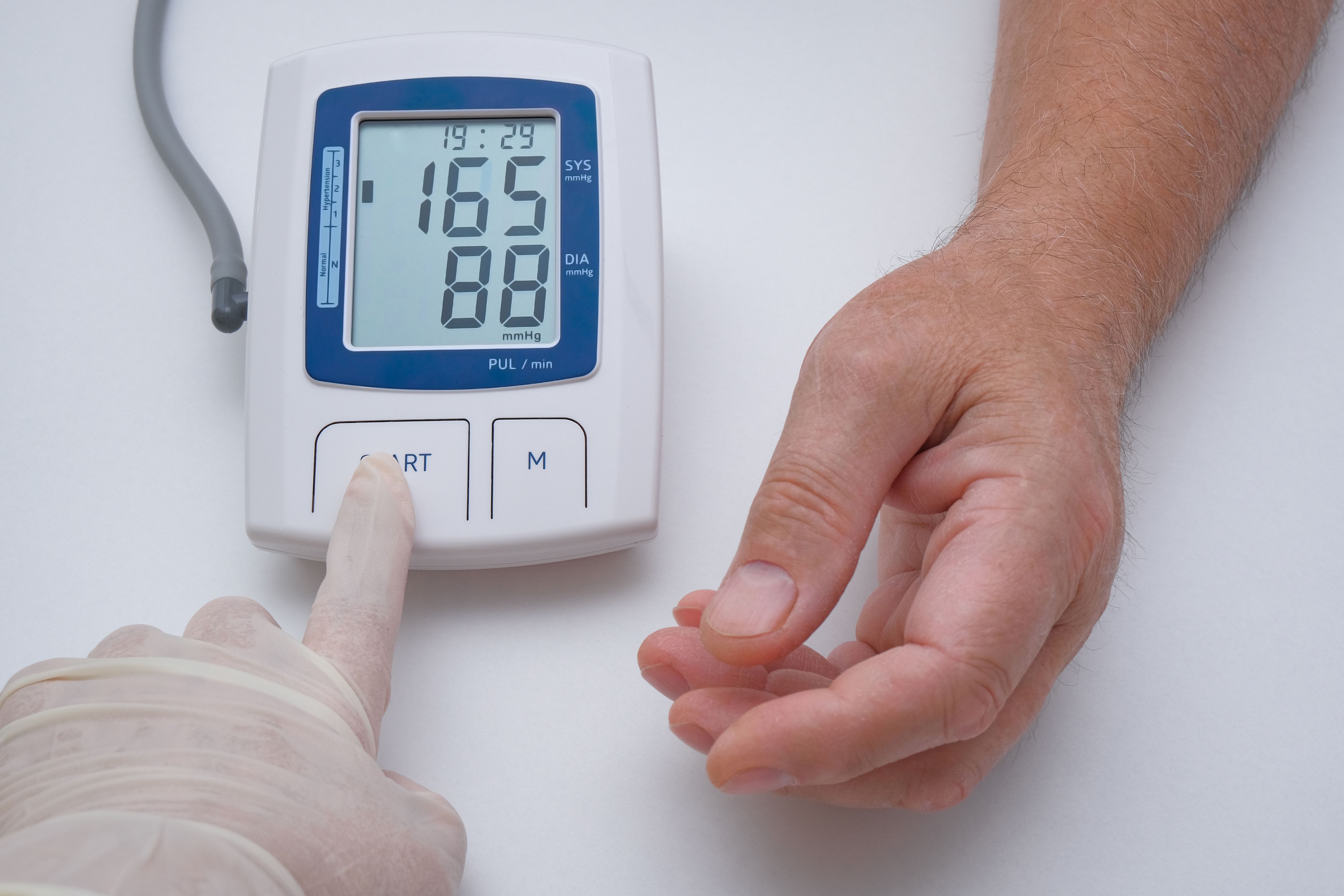 orvos idős férfi vérnyomását méri otthon 