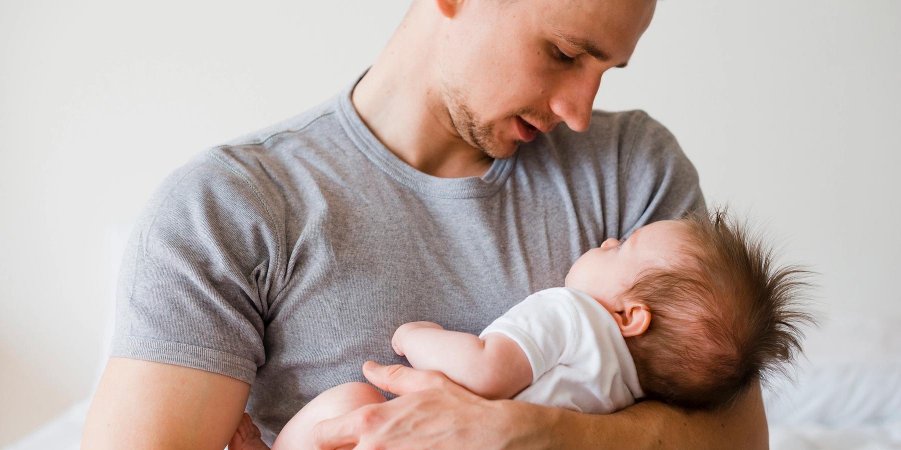 kisbabát karjaiban tartó apa