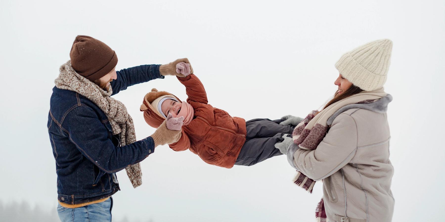 A gyermek a téli tevékenységeket élvezi a családjával