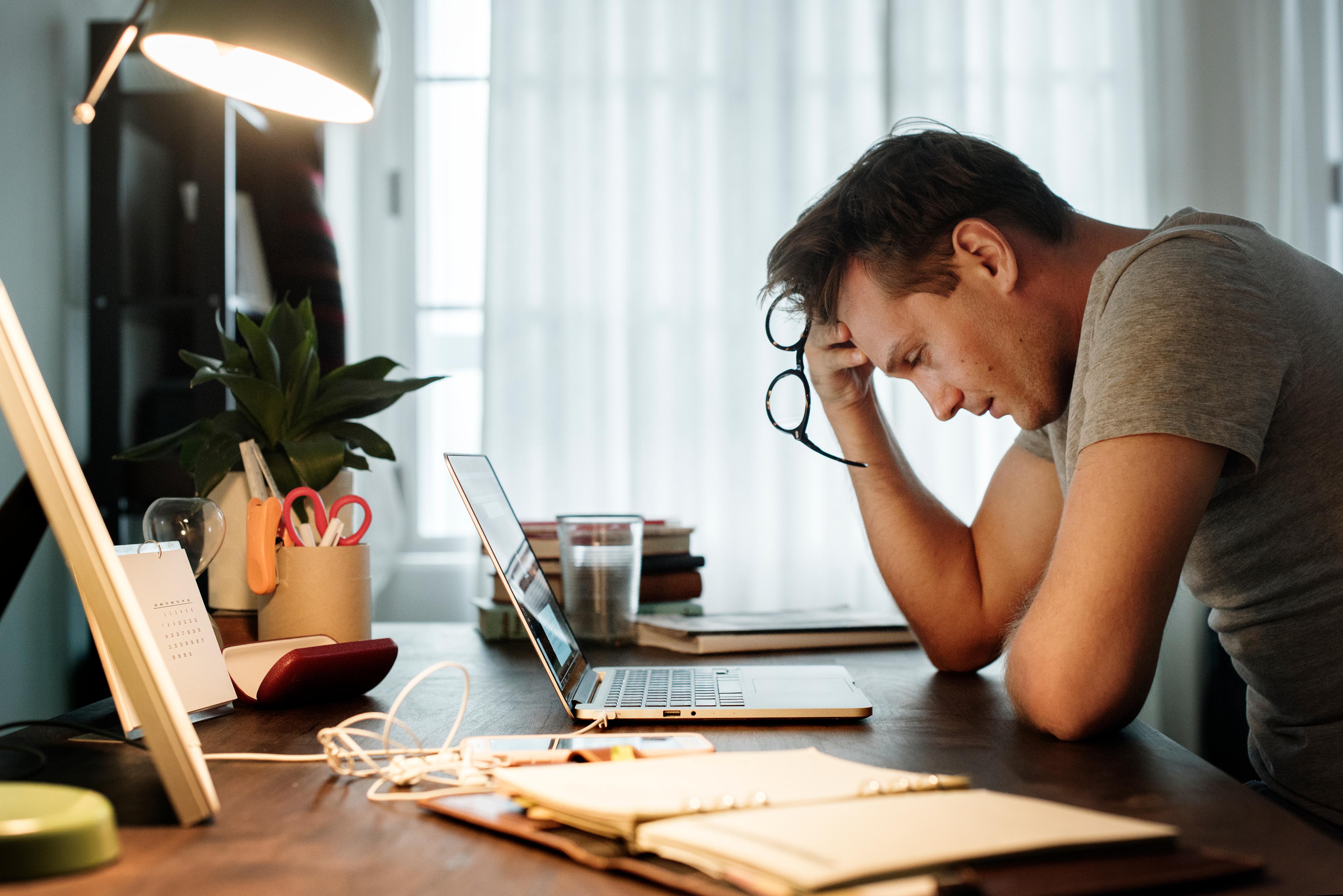 stresszelő férfi dolgozik laptopon 