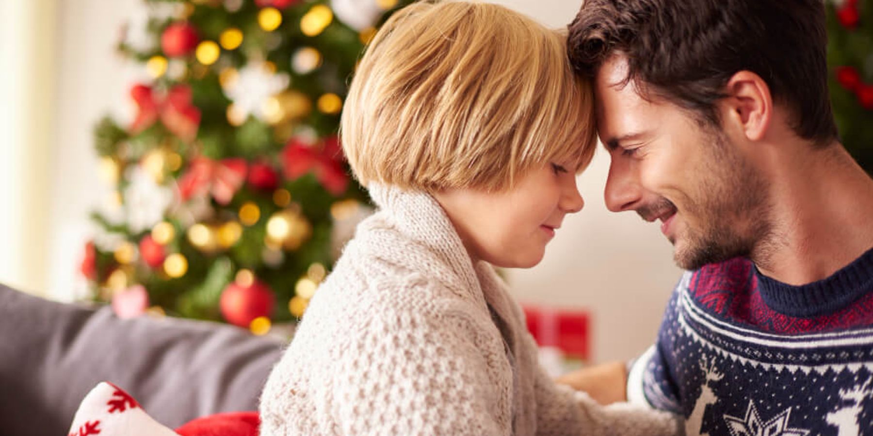 Apuka és gyermeke közötti szeretetteljes pillanat, a háttérben karácsonyfa