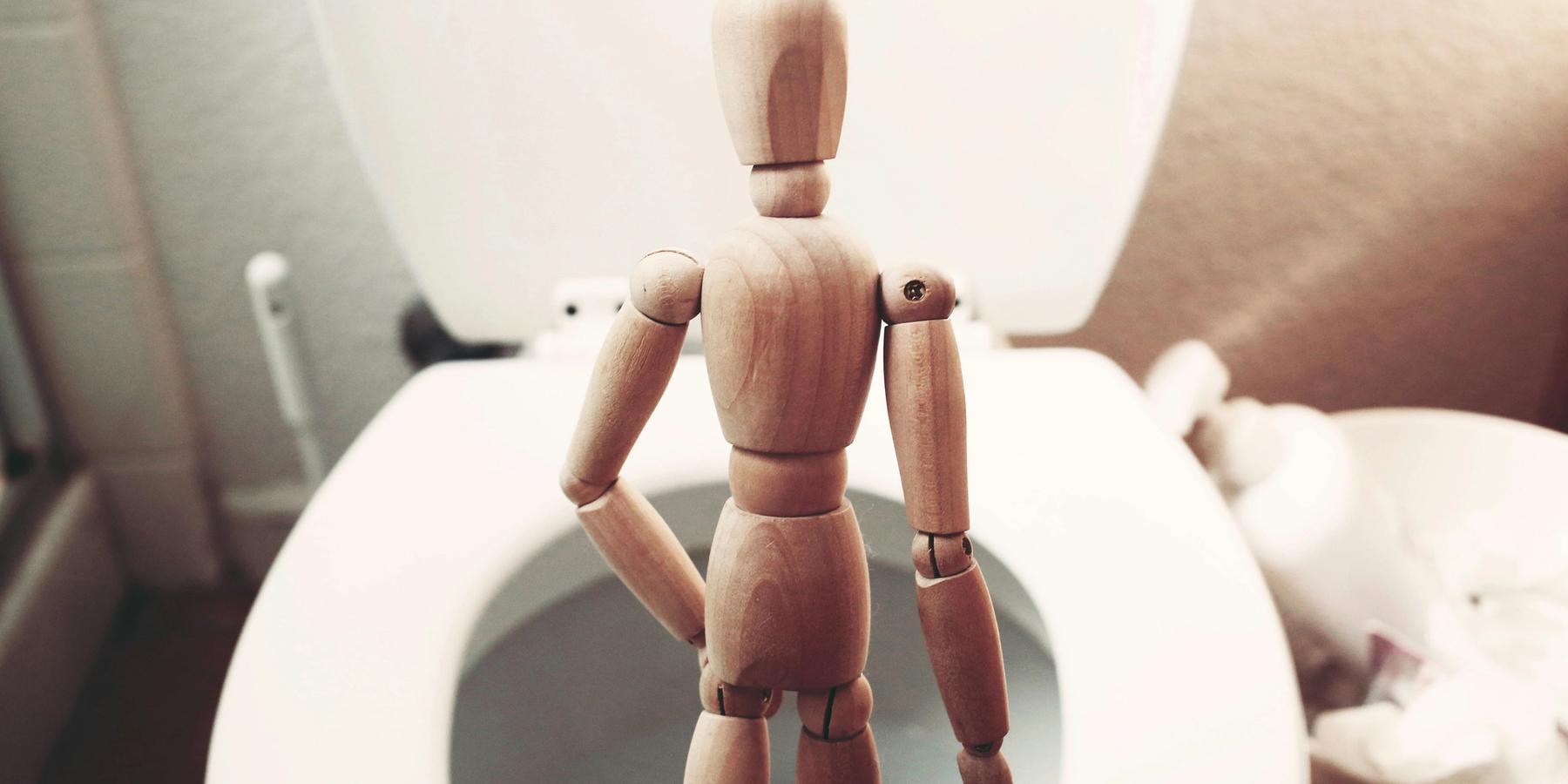 barna fából készült próbababa fehér kerámia WC-csészén