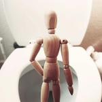 barna fából készült próbababa fehér kerámia WC-csészén