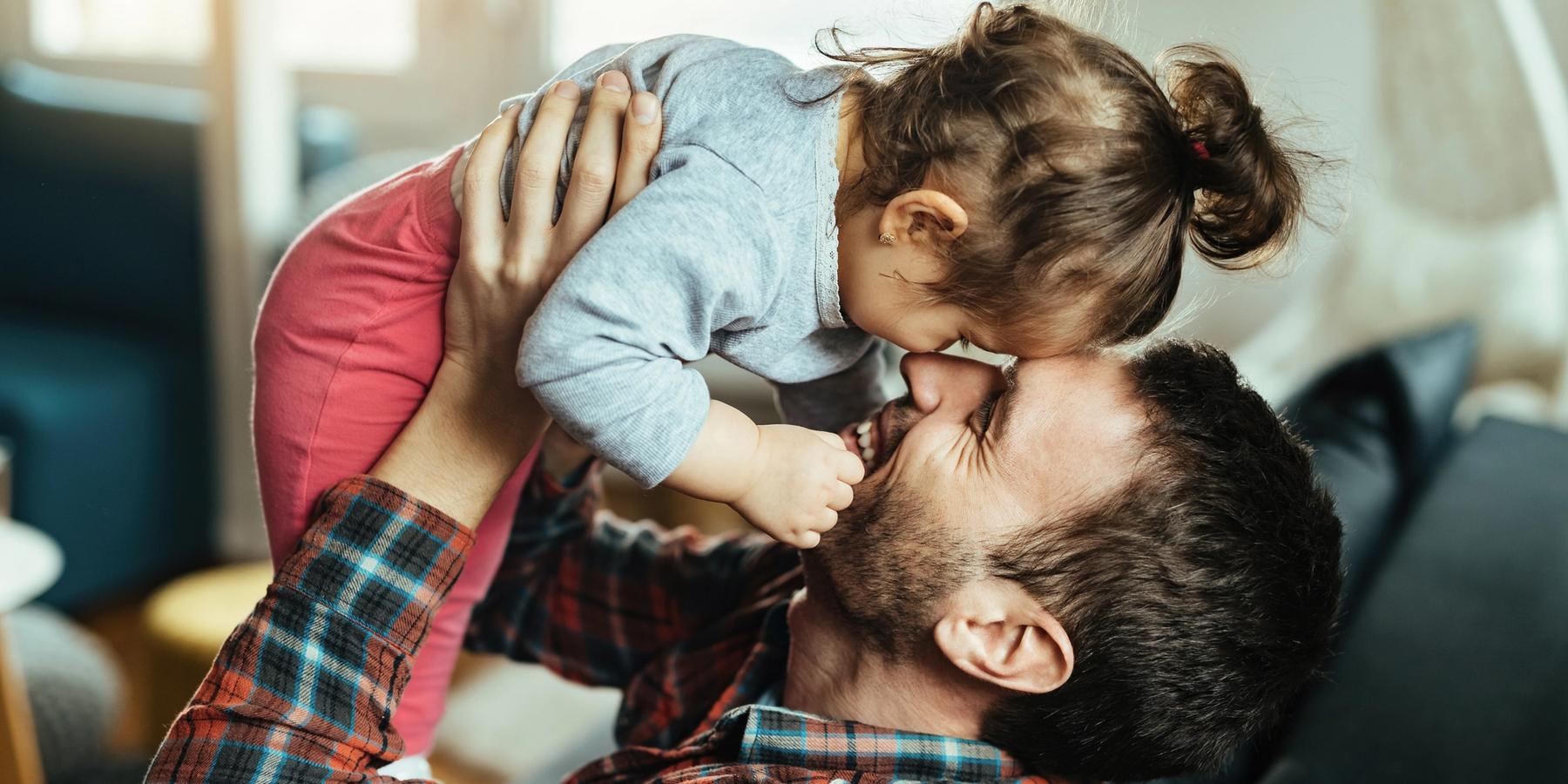 Fiatal, játékos apa és kislánya együtt szórakoznak otthon