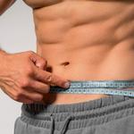 Izmos férfi mérőszalagot tart a dereka körül