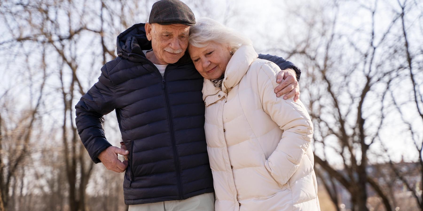 Közeli felvétel egy idősebb párról, akik együtt sétálnak.