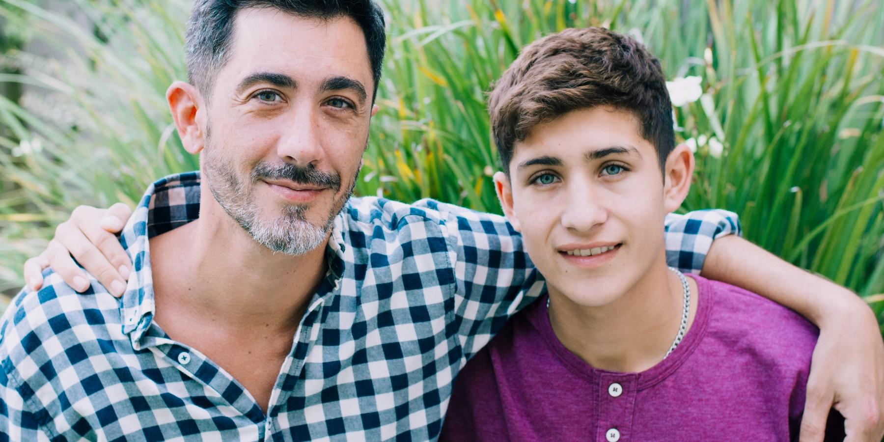 Apa és kamasz fia átkarolja egymást