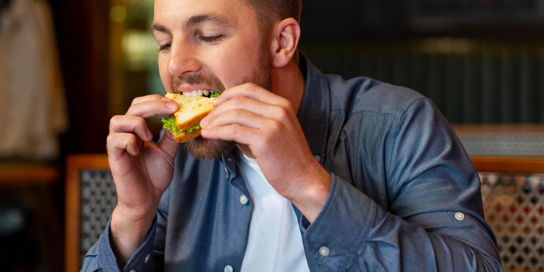 Középkorú férfi eszik az asztalnál