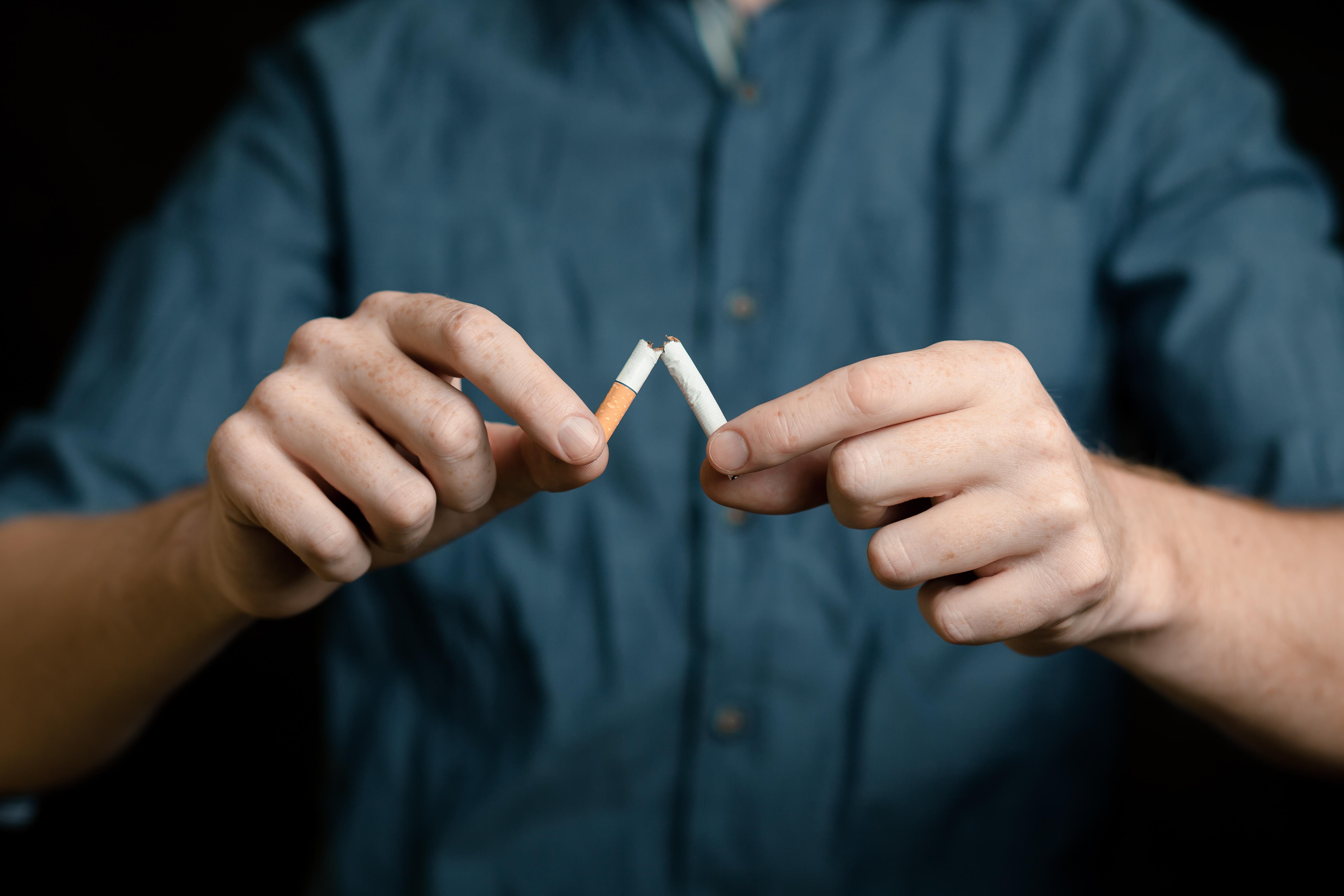 férfi kettétöri a cigarettát
