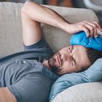 Frusztrált fiatalember jégzsákot tart a fején