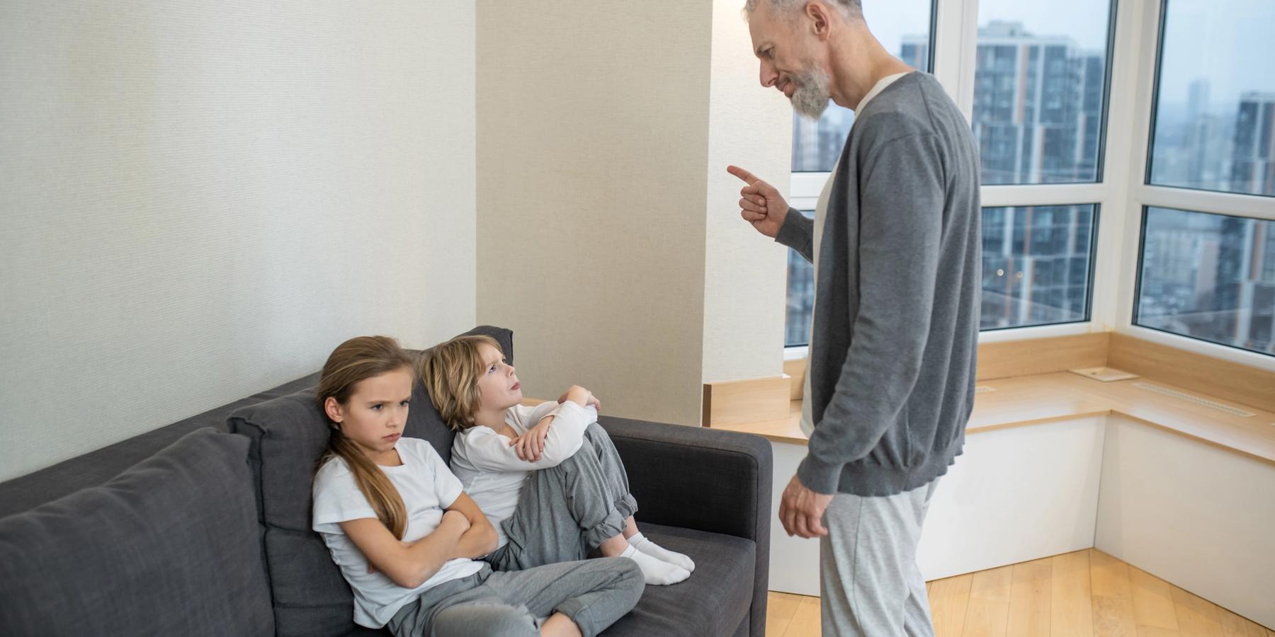 gyereknevelés. Ősz hajú, szakállas férfi beszélget a gyerekeivel, és elégedetlen